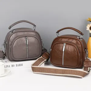 Detailaufnahme von modischen weichen Damen Leder Mehrschicht Umhängetaschen in Grau und Braun