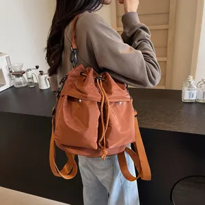 Detailansicht des stilvollen braunen Rucksacks in einer Café-Umgebung für den Alltag.