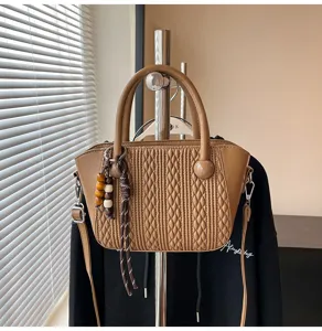 Braune gesteppte Damenhandtasche Detailaufnahme, elegante Vintage Umhängetasche mit Anhänger.