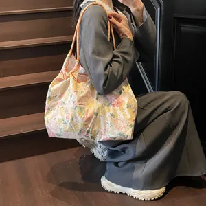 Nahaufnahme der floralen Kordelzug-Tasche mit Stoffmuster und Trageriemen Detail.