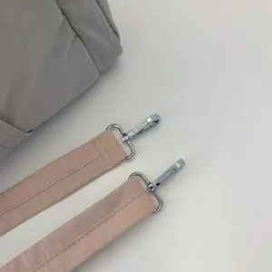 Puffer Tasche Schultergurt Detailansicht mit rosa Stoffgurt und silbernen Metallbeschlägen.
