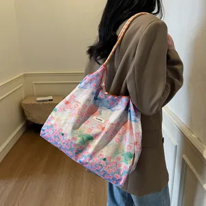 Detailansicht der lässigen Blumen Schultertasche aus Stoff mit praktischem Kordelzug.