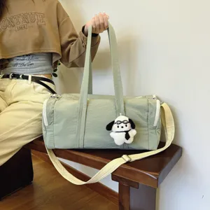 Hellgrüne Reisetasche Detail mit robustem Stoff, stabilen Griffen und süßem Welpenanhänger.