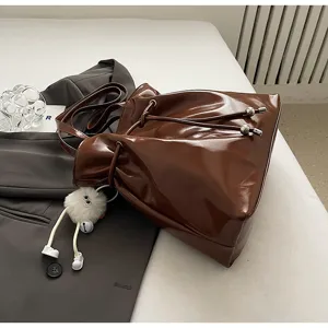 Koreanische Lackleder Beuteltasche, modische braune Schultertasche mit Plüsch-Anhänger.