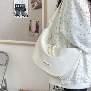 Detailansicht der lässigen weißen Canvas-Knödeltasche, stylisch und geräumig im Alltag.
