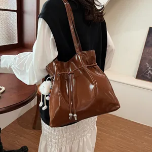 Modische braune Lackleder Schultertasche mit Kordelzug für den stilvollen Damenalltag.