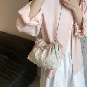 Detailansicht der sommerlichen Strohtasche mit rosa Perlenhenkel und feiner Kette.