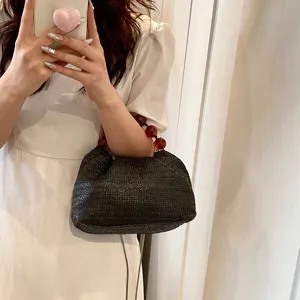 Schwarze geflochtene Strohtasche mit eleganten Bernsteinperlen Griff ideal für den Sommer.