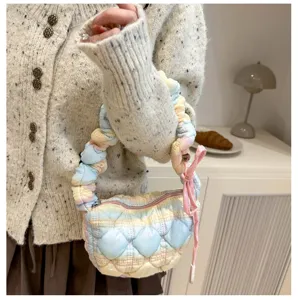 Nahaufnahme der pastellfarbenen gesteppten Wolken-Handtasche mit plissiertem Riemen, Detail.