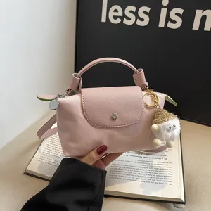 Rosa Nylon Mini Umhängetasche Knödel Tasche mit Griff Klappe Druckknopf und Plüsch Anhänger.