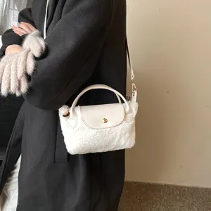 Detailansicht einer flauschigen Plüsch-Umhängetasche mit Lederklappe und weicher Textur.