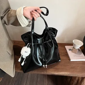 Schwarze Lackleder Handtasche für Damen, schicke Achseltasche mit süßem flauschigen Anhänger.