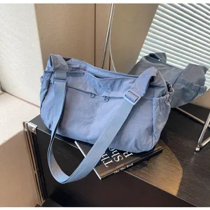 Detailansicht der lässigen blauen Nylon-Umhängetasche mit verstellbarem Riemen und Reißverschluss.