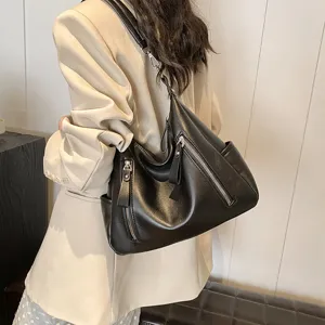Detailansicht der stilvollen schwarzen Schultertasche aus Kunstleder mit Reißverschlüssen.