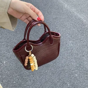 Detailansicht der Retro-Geflochtenen Eimer Tasche mit charmanter Holzperlen Quaste.