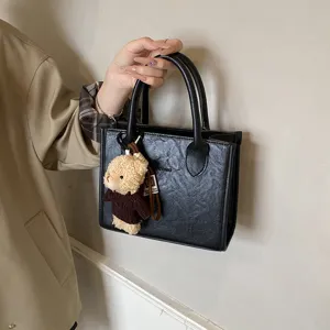 Schwarze strukturierte Handtasche mit niedlichem Plüschbärchenanhänger minimalistische Damentasche