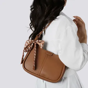 Elegante braune Ledertasche fuer Damen mit stilvollem Karoschal ideal fuer den Alltag.