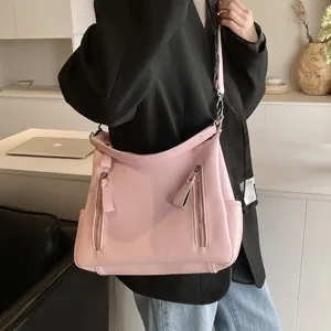 Rosa Leder Umhängetasche Detail mit mehreren Taschen und weicher Beuteltaschenform.