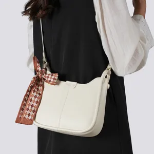 Minimalistische weiße Leder-Hobo-Umhängetasche mit stilvollem braunem Karo-Schal für Pendler.