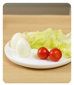 Detailed view of boiled eggs and fresh vegetables served on a clean white ceramic plate.