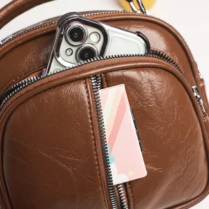 Nahaufnahme der braunen Mehrfach-Reißverschluss Softleder Damentasche Detail Textur.
