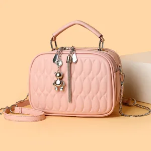 Rosa gesteppte Umhaengetasche mit Kette, elegante Handtasche mit stilvollem Baerenanhaenger.