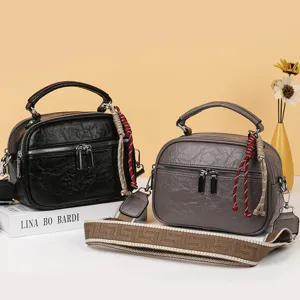 Nahaufnahme mehrlagiger weicher Ledertaschen in Schwarz und Grau mit schicken Riemen.
