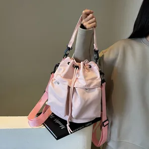 Modische rosa Nylon-Beuteltasche mit Tunnelzug und praktischen Vordertaschen.