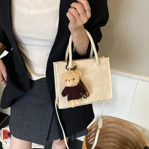 Modische Herbst Umhängetasche Eimerbeutel mit süßem Bären Anhänger und stilvollem Design.