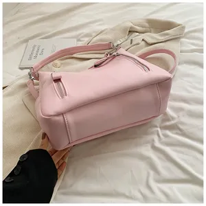 Detailansicht der stilvollen rosa Umhängetasche aus weichem Leder mit praktischen Reißverschlüssen.