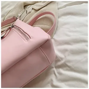 Rosa Leder Umhängetasche Detail zeigt Reißverschlusstasche und weiches Texturmaterial.