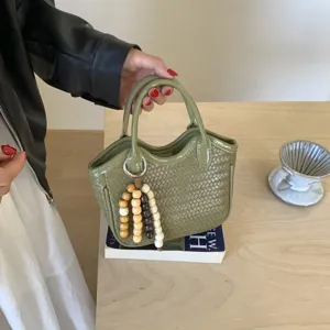Retro grüne gewebte Handtasche mit Perlenanhänger, stilvolle Beuteltasche für den Damenalltag.