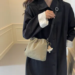 Detailansicht der lässigen Nylon Beuteltasche mit süßem Strickmützen Plüschtier Anhänger.