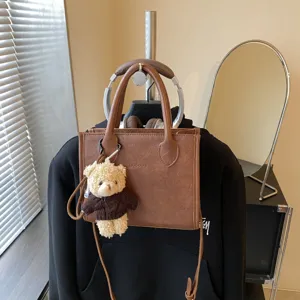 Braune PU Leder Tote Tasche mit Teddybär Plüsch Anhänger, trendige minimalistische Umhängetasche.