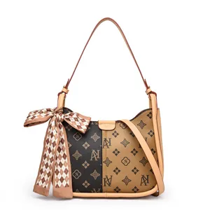 Einfashionige Damen Schultertasche mit Vintage Monogramm Muster und schickem Seidenschal.