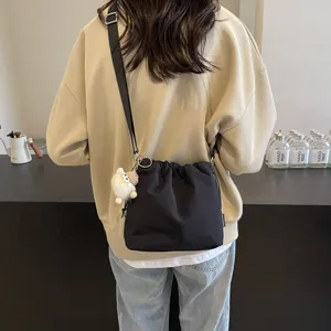 Lässige Nylon Eimer Tasche für Damen, trendige Umhängetasche mit süßem Plüsch-Anhänger.