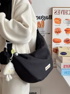 Lässige schwarze Canvas-Damen-Schultertasche, stilvolle Crossover-Tasche mit süßen Anhängern.