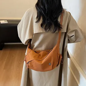 Detailansicht der lässigen Nylon-Umhängetasche in Karamel mit verstellbarem Riemen und Kordel.
