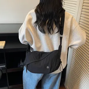 Detailaufnahme einer schwarzen Nylon-Umhängetasche vom Model getragen, lässig und praktisch.