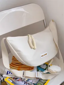 Detailansicht der weißen Canvas Umhängetasche mit geflochtenen Ziehern und kleinem Täschchen.