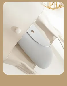 Silicone makeup bag detail shot, minimalist beige leather texture, portable travel cosmetic case.