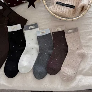 Chaussettes mi-mollet à pois rétro pour femmes avec poignets contrastés et étiquettes.