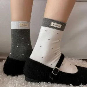 Gros plan de chaussettes mi-mollet à pois pour femmes avec poignets contrastés et étiquette.