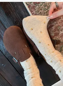 Calzini vintage da donna in cotone floreale a metà polpaccio abbinati a zoccoli marroni primaverili.