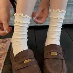 White ruffled mid-tube socks with delicate lace cuffs, comfortable cotton fabric for women.