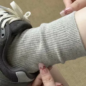 Primo piano di calzini a coste grigi da donna abbinati a sneakers, comodo cotone morbido.