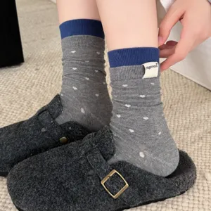 Detaillierte Nahaufnahme von grauen Mittelsocken mit süßem Herzmuster und blauen Bündchen.