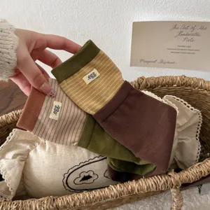 Detailed shot of Japanese style colorblock striped mid-calf socks with egg brand label.