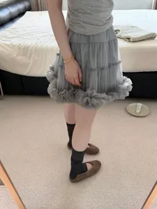 Detail shot showcasing Korean style grey layered tulle skirt and scrunched socks with brown flats.