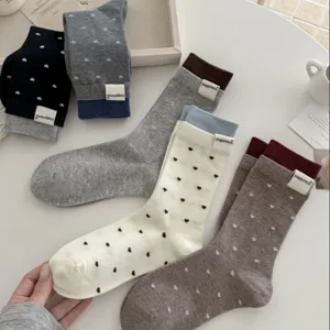 Detailansicht koreanischer süßer Strickstrümpfe mit Herzmuster und feinem Webetikett.